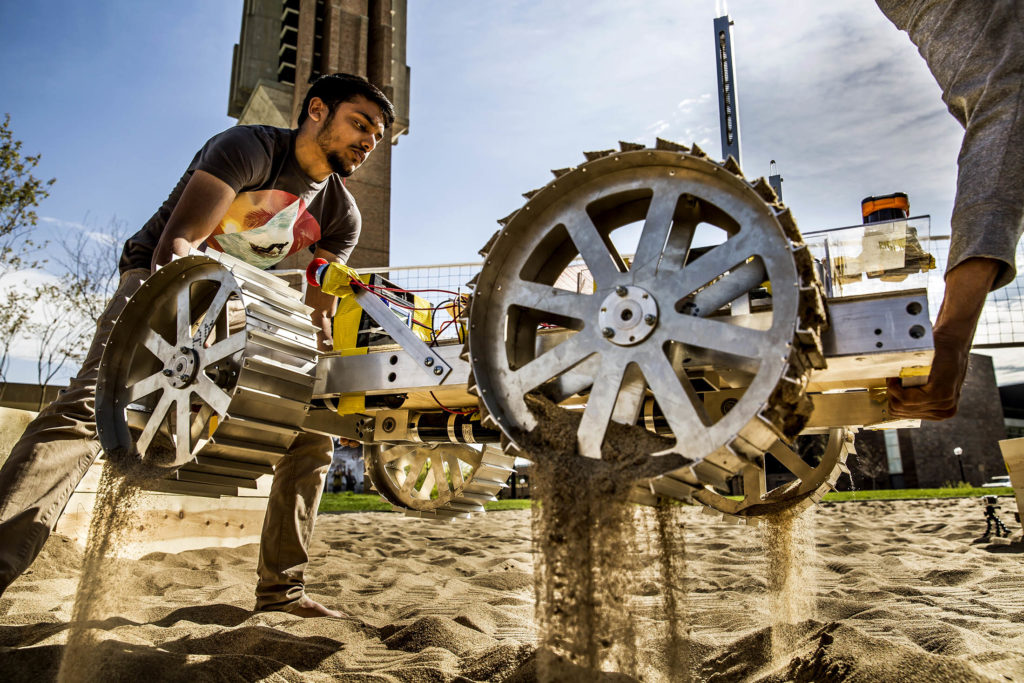 wheeled robotic vehicle being lifted out of sand